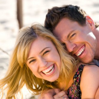 Happy couple embracing and laughing on the beach